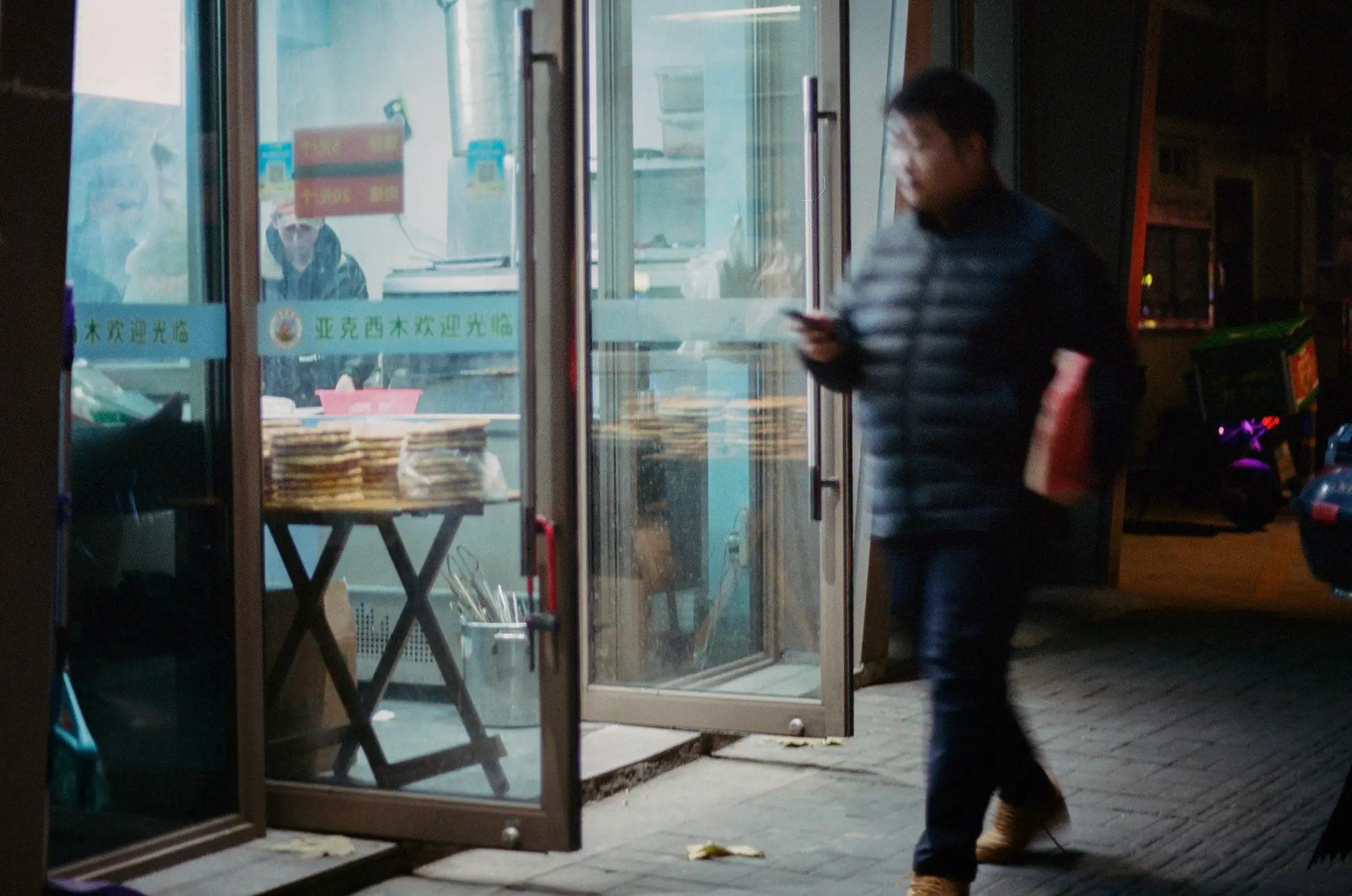Owner checking phone shopfront
