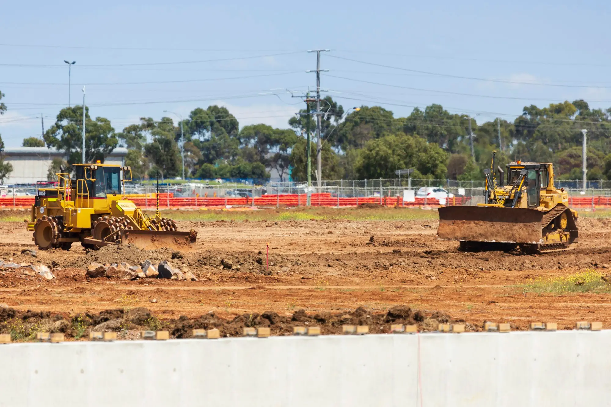 Yellow earthmoving machinery on a dirt site in Victoria